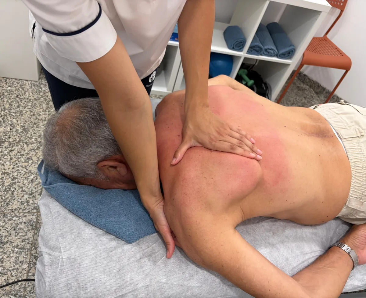 Fisioterapeuta a aplicar tratamento manual nas costas do utente